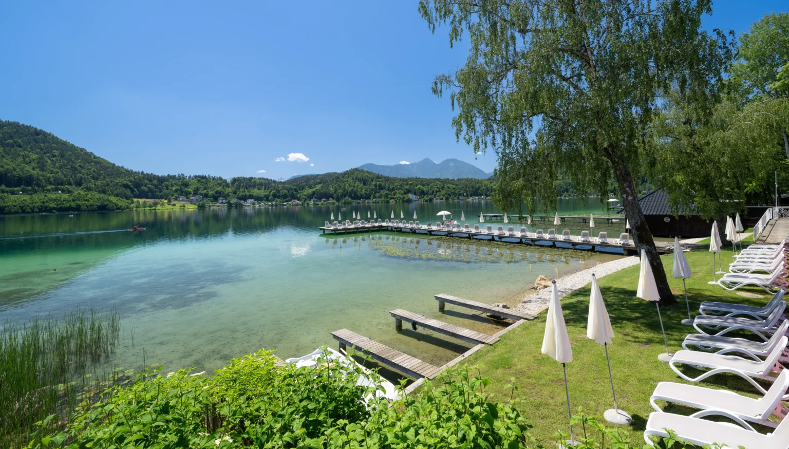 Flach verlaufender Badestrand des Strandhotel Orchidee am Klopeiner See mit Wasserlift
