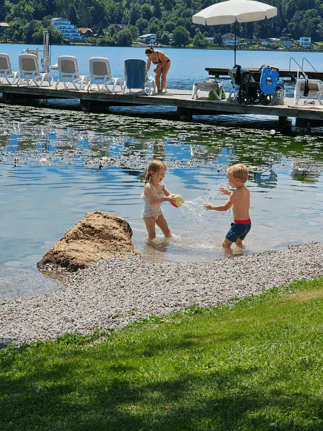 Kinder spielen am flachen, kinderfreundlichen Badestrand des barrierefreien Strandhotel Orchidee der Inklusion direkt am Klopeiner See in Kärnten.